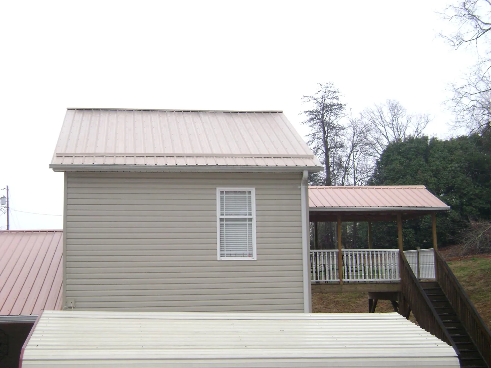 Tan metal roofs on a two story addition and attached porch, from a Roof Replacement job in Kennewick